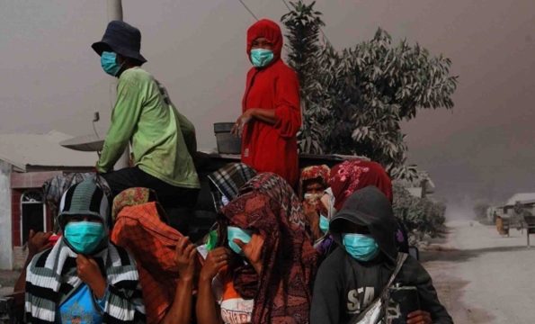 Warga desa di kaki Gunung Sinabung terpaksa mengenakan masker saat beraktivitas di luar rumah (merdeka.com)